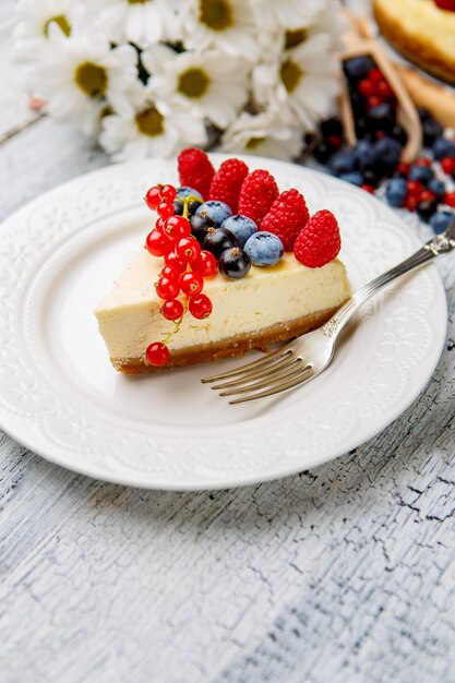 Cheesecake de framboesa e mirtilo na mesa de madeira