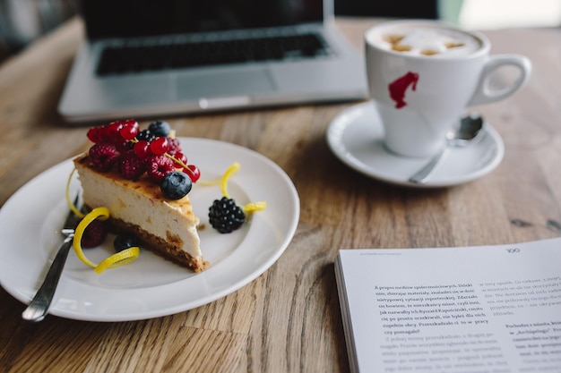 Cheesecake de framboesa e mirtilo saboroso tradicional na mesa de madeira