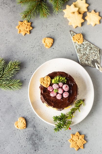 Cheesecake de Nova York com ganache de chocolate, framboesas e biscoitos com ramos de abeto.