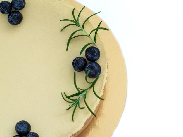 Cheesecake decorado com bagas de mirtilo e raminhos de alecrim