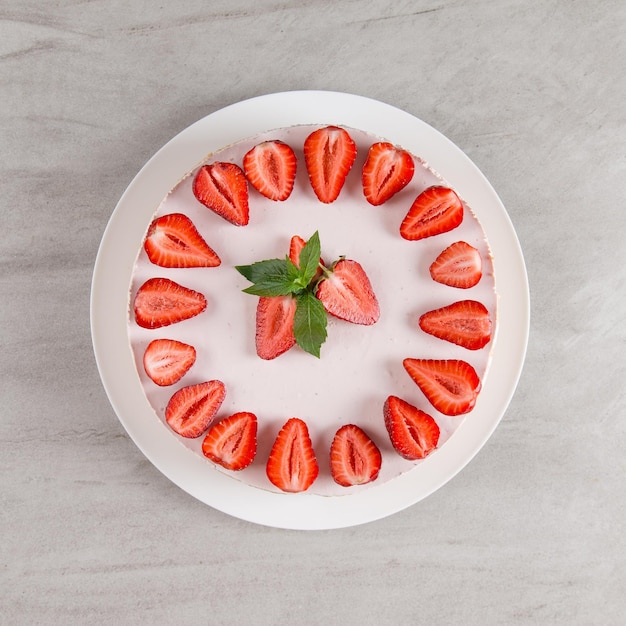 Cheesecake delicioso de café da manhã doce com morangos frescos e receita caseira de menta sem assar em uma mesa de pedra copiar espaço