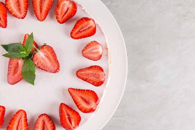 Cheesecake delicioso de café da manhã doce com morangos frescos e receita caseira de menta sem assar em uma mesa de pedra copiar espaço