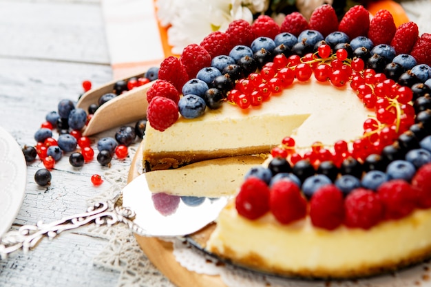 Cheesecake de frambuesa y arándano en mesa de madera