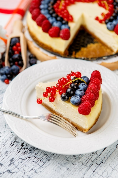 Cheesecake de frambuesa y arándano en mesa de madera