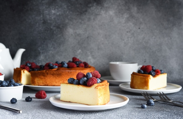 Cheesecake new york rebanada de tarta de queso con frutos rojos y una taza de té