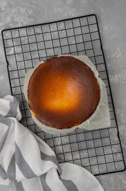 El cheesecake de San Sebastián terminado tiene la forma de una rejilla de enfriamiento sobre un fondo de hormigón gris. El proceso de elaboración del cheesecake de San Sebastián. Receta paso a paso.
