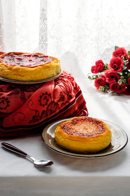 Cheesecakes em uma mesa elegante ao lado de uma janela com cortinas brancas