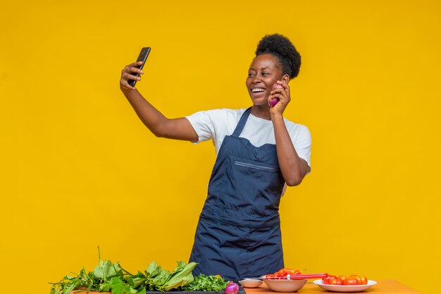 Chef africana haciendo una videollamada y mostrando sus ingredientes