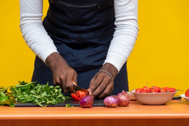 Chef africano cortando un tomate