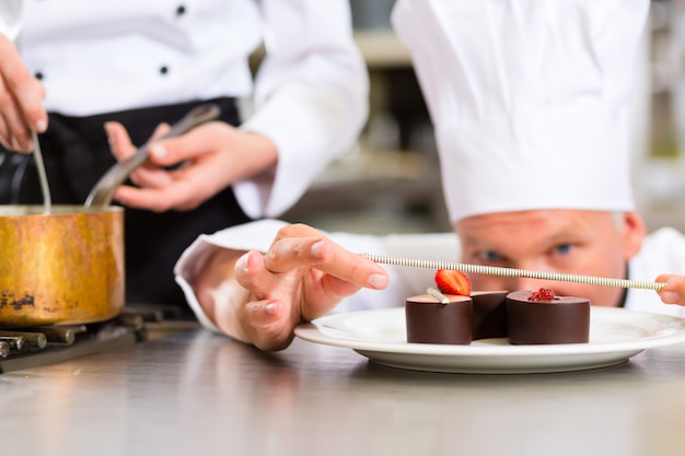 Chef als Patissier, der im Restaurantnachtisch kocht