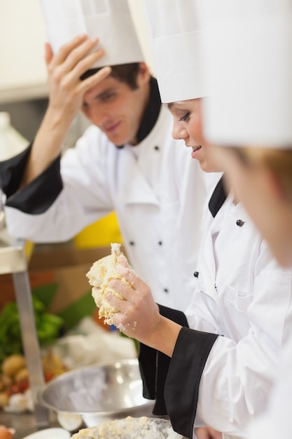 Un chef amasando masa mientras otros están mirando