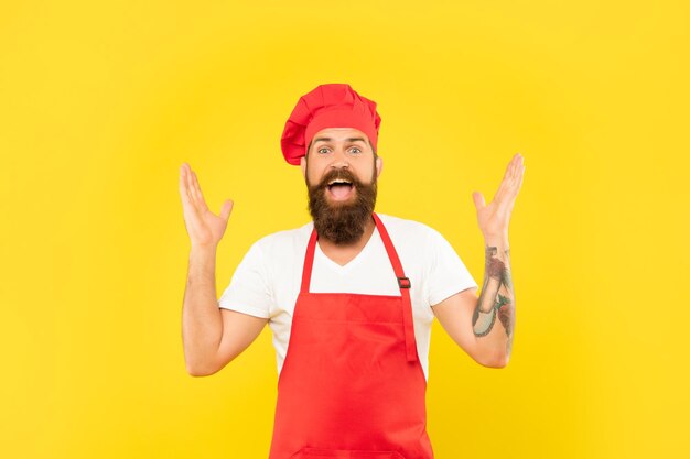 Chef animado em toque e avental feliz gritando com felicidade de fundo amarelo de braços abertos