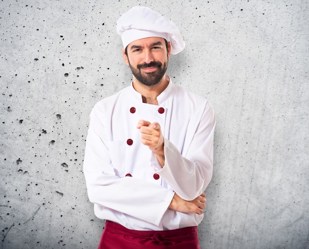 Chef apuntando a la parte delantera sobre fondo blanco