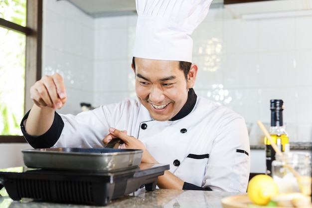 Chef asiático cocinando en restaurante de cocina