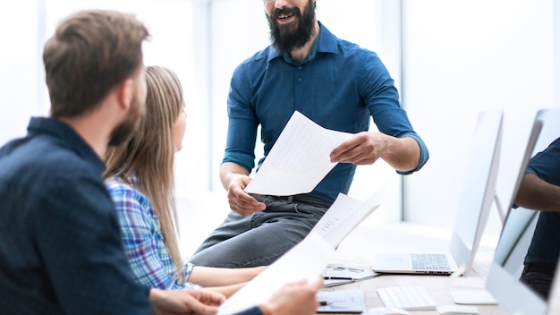 Chef bespricht mit Mitarbeitern einen neuen Vertrag. Büro wochentags