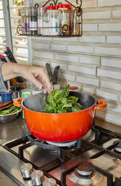 El chef blanqueó el manojo de albahaca en una olla a fuego lento