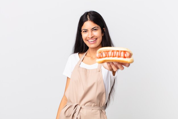 Foto chef bonita hispana mujer sosteniendo un hot dog