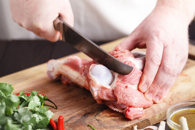 Chef Butcher Lammfleisch mit Messer schneiden