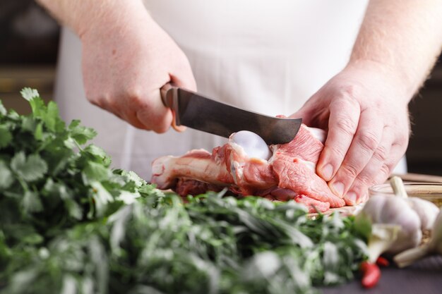 Chef Butcher Lammfleisch mit Messer schneiden