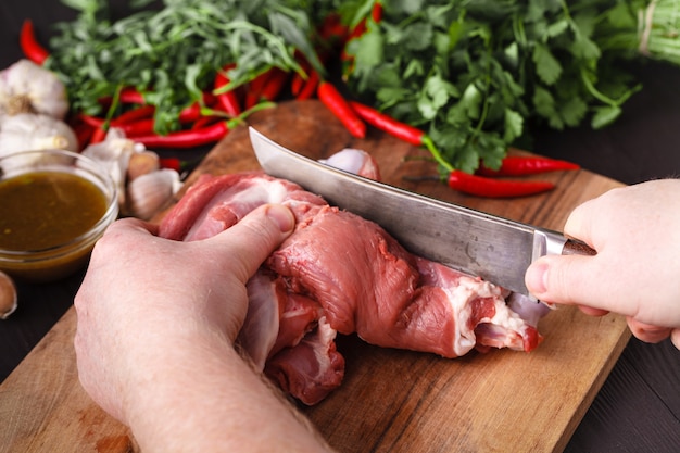 Chef carnicero cortando carne de cordero con cuchillo