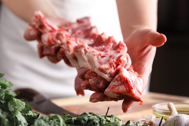 Chef carnicero cortando carne de cordero con cuchillo