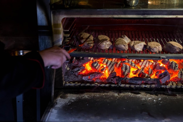 Chef cocina carne a las brasas en el restaurante