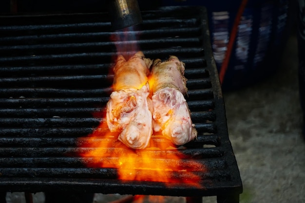 El chef cocina codillos de cerdo crudos para preparar deliciosos platos con lanzallamas manuales