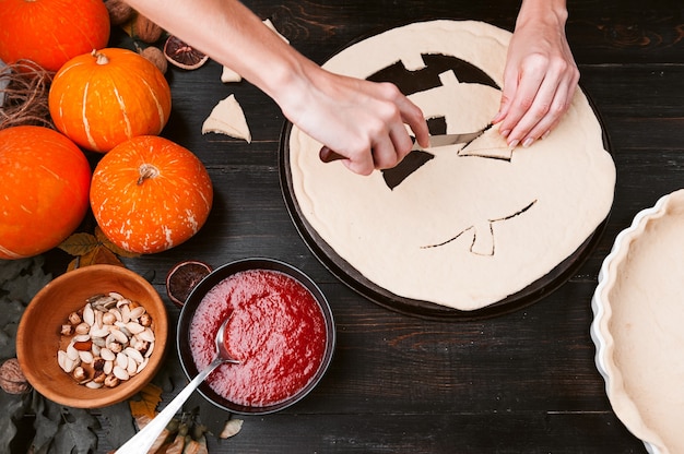 Chef cocina un pastel para Halloween con un relleno de mermelada de calabaza y fresa y melocotones