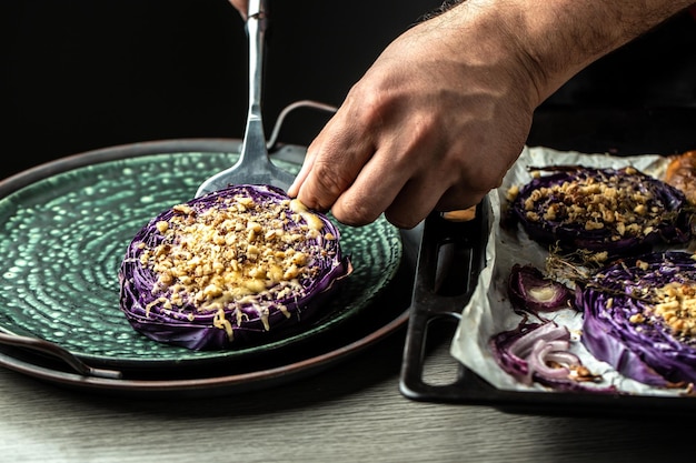 Chef cocina plato tradicional alemán de repollo rojo al horno con nueces, membrillo y manzanas Filetes de repollo rojo asado vegano Fondo de receta de alimentos