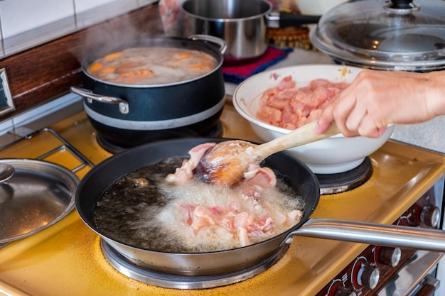 Chef cocina pollo freír hervir en aceite con sartén