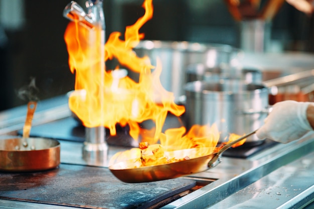 Chef de cocina de verduras en una sartén wok.