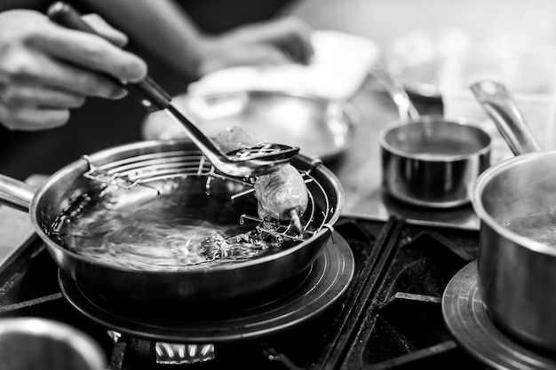 Chef cocinando en una cocina, chef en el trabajo, blanco y negro