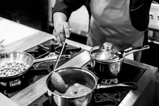 Chef cocinando en una cocina, chef en el trabajo, blanco y negro