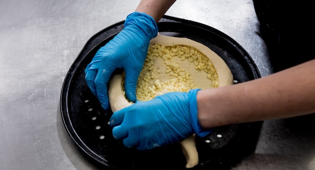 Chef cocinando khachapuri con queso y huevo. Cocina nacional georgiana. Restaurante.