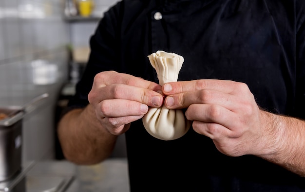 Chef cocinando khinkali georgiano o wonton japonés. Comida tradicional