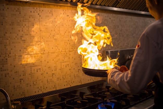 Chef cocinando con llama