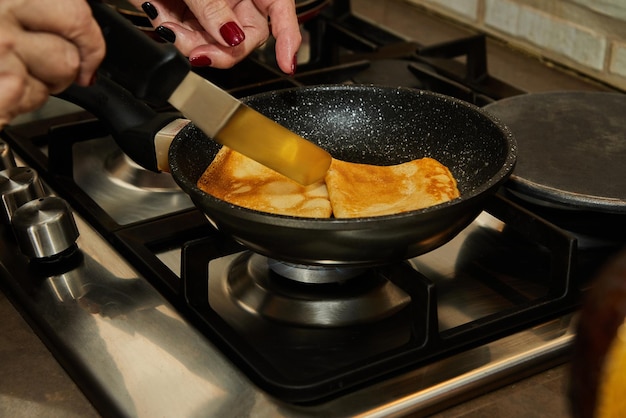 Chef cocinando panqueques Crepe Suzette con coñac y salsa cítrica