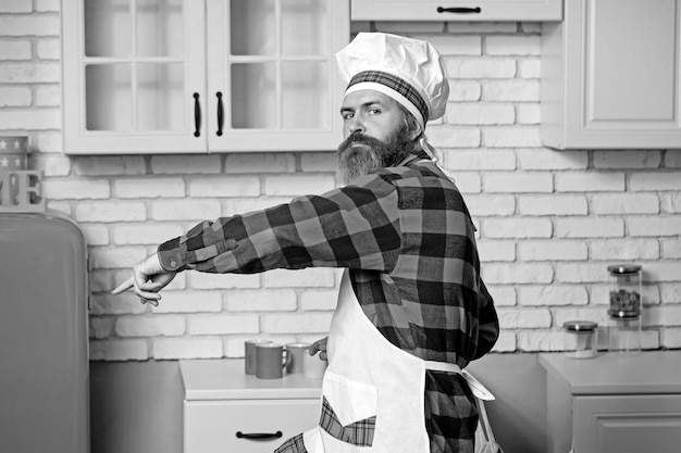 Chef cocinero haciendo sabrosos platos deliciosos Cocinero barbudo confiado en uniforme blanco