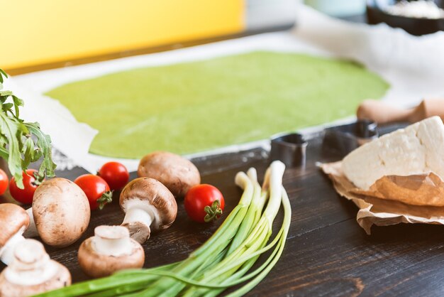 Chef cocinero paso a paso hace ravioles verdes en forma de corazón para una cena festiva