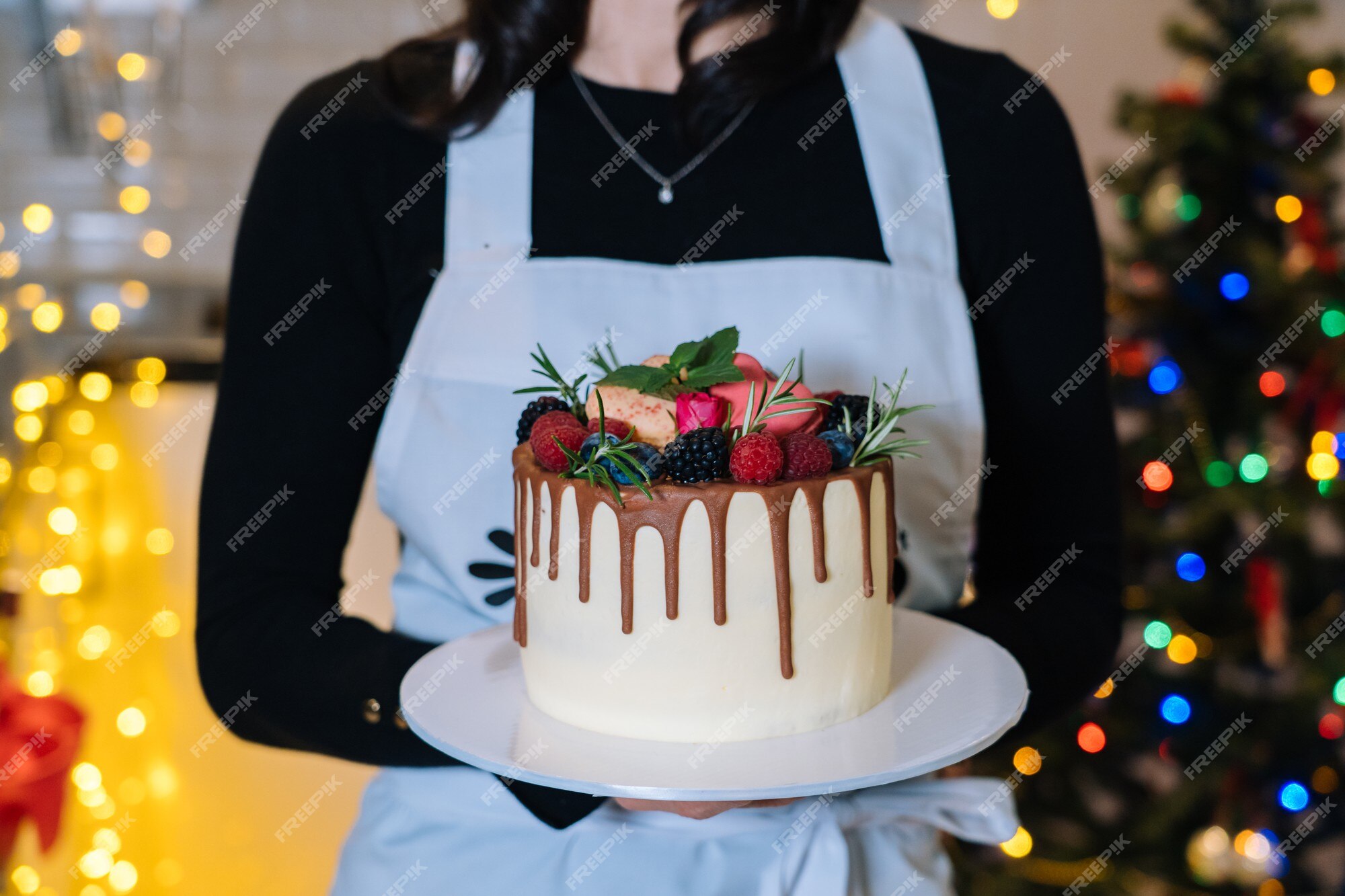 Chef-cocinero sostiene pastel de navidad casero con fruta. feliz año nuevo  y feliz navidad | Foto Premium