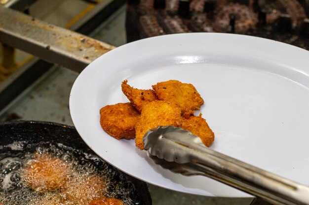 Chef colocando arepa fritas en plato, toma cerrada, alimentos fritos