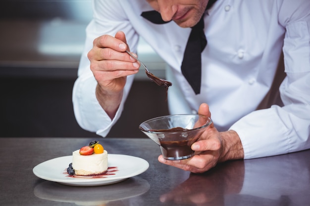 Chef, colocando molho de chocolate em uma sobremesa