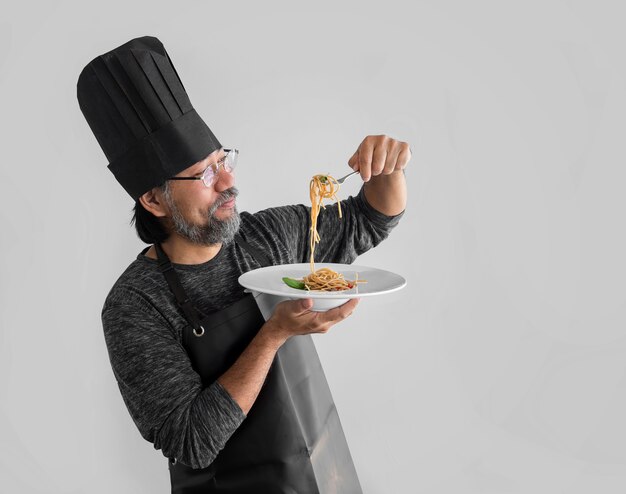 Chef come fideos italianos o asiáticos. Concepto de menú tradicional.