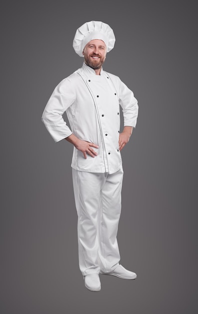 Chef confiado en uniforme sobre fondo gris