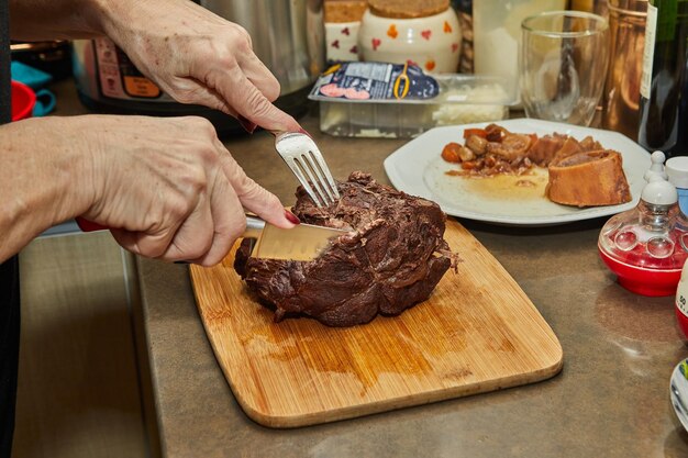 Chef corta fatias de pedaço de carne cozida