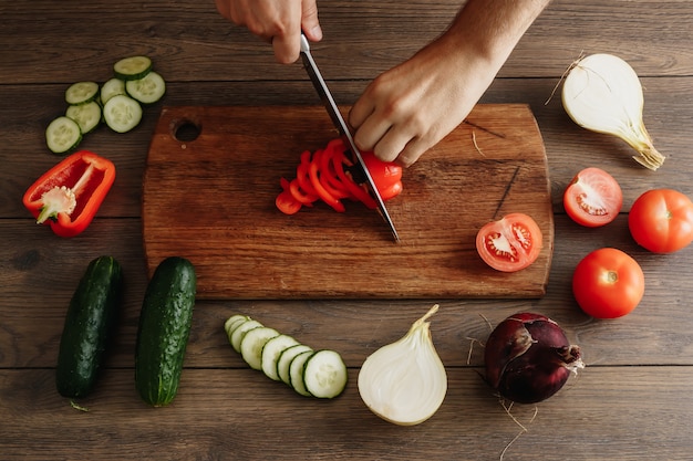 El chef corta verduras frescas y sabrosas para cocinar.