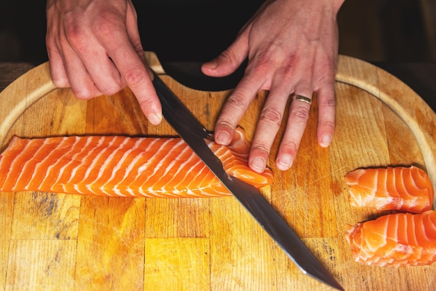 Chef cortando filete de salmón para sushi