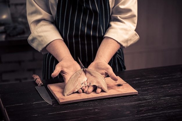 Chef cortando o peixe em uma placa