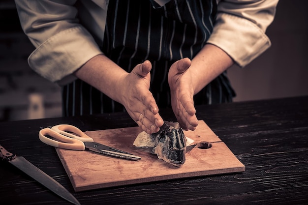 Chef cortando o peixe em uma placa