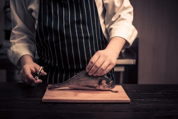 Chef cortando el pescado en una tabla